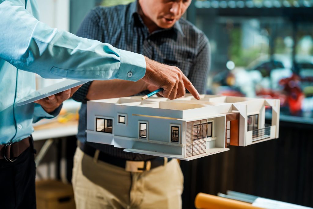 Residential architects examining a home model